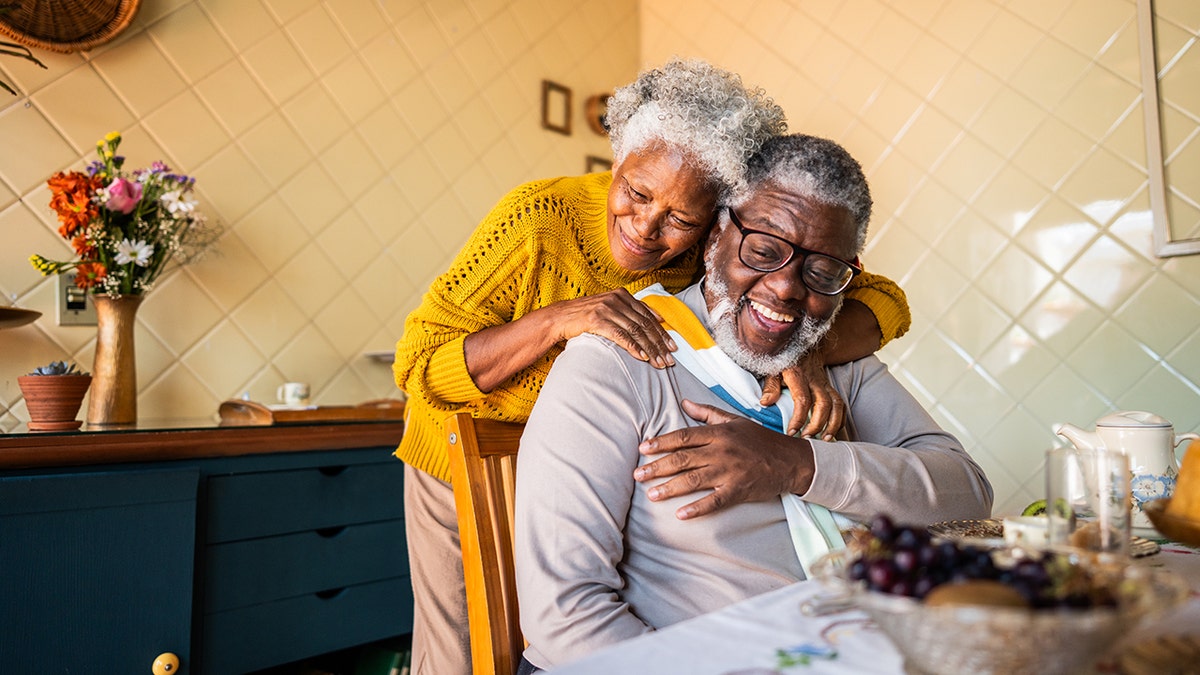 Happy senior couple embracing at home