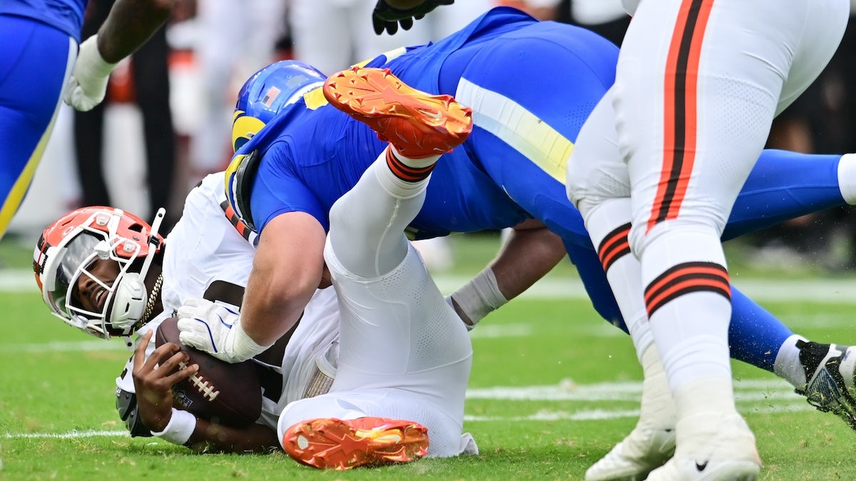 Los Angeles Rams defensive tackle Bill Norton (97) tackles Cleveland Browns quarterback Shedeur Sanders (12) during the second half at Huntington Bank Field.