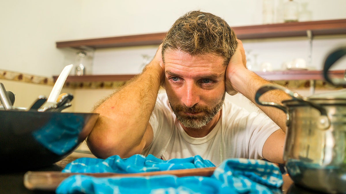 Man overwhelmed by cleaning duties