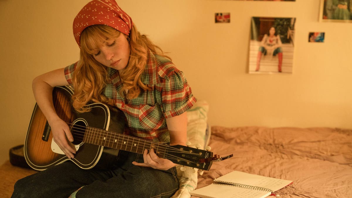 sydney sweeney plays the guitar in a scene from americana