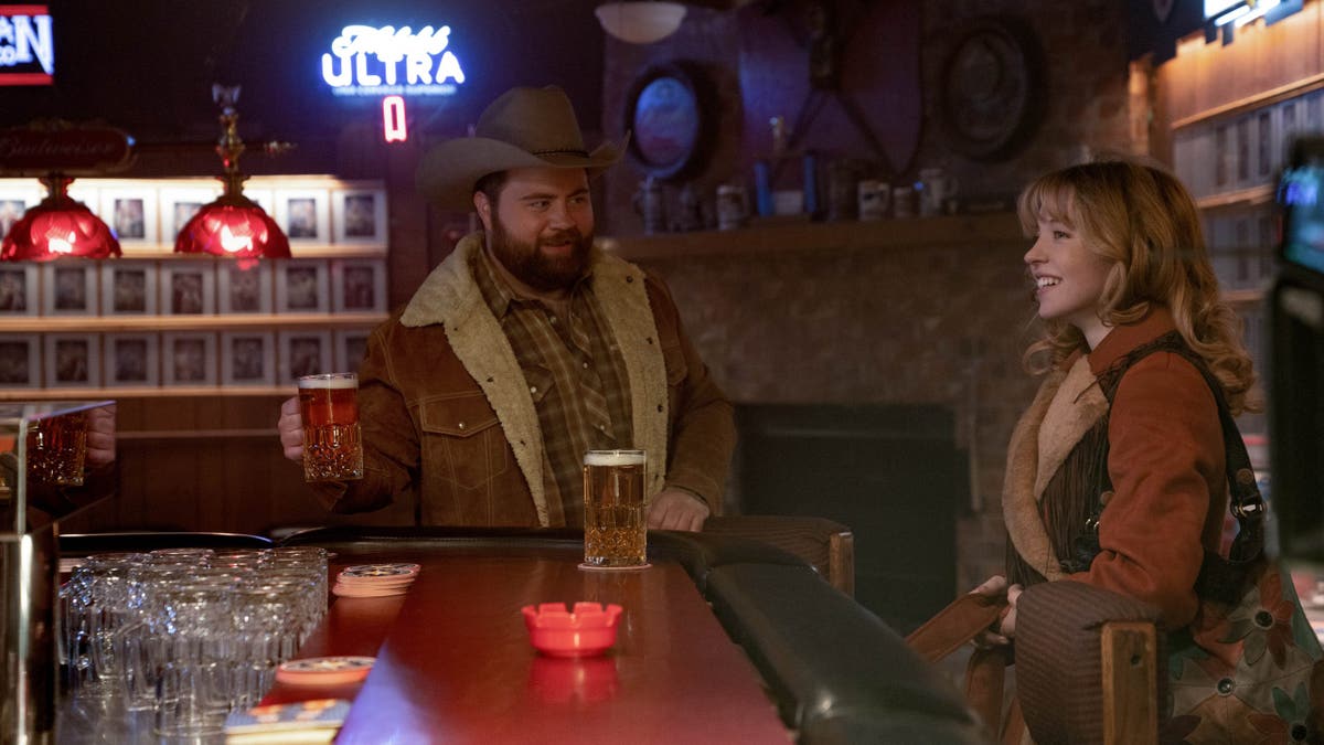 Sydney Sweeney at a bar with Paul Walter Hauser in Americana.