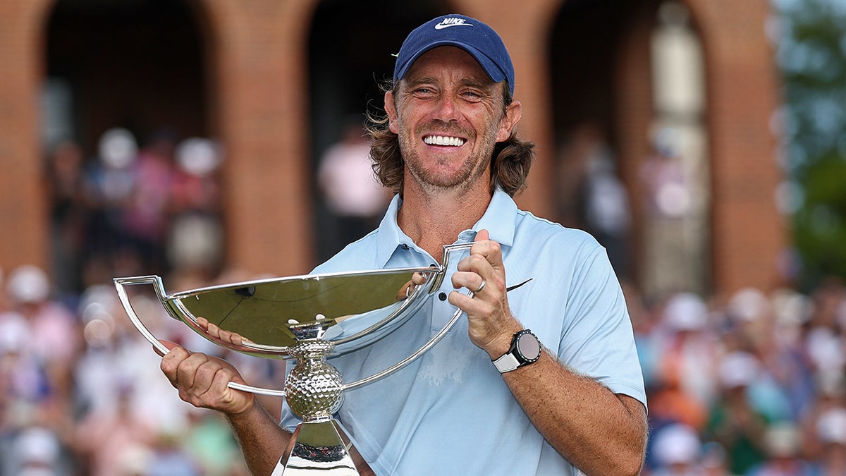 Tommy Fleetwood celebrates with Tour Championship trophy