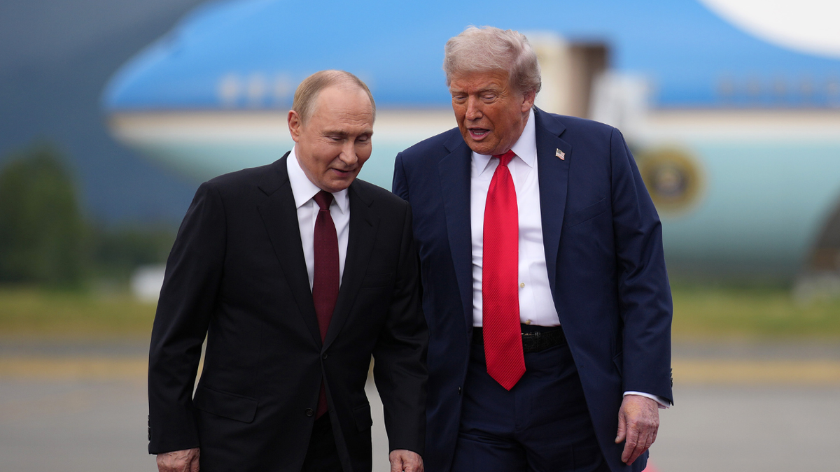 US President Donald Trump walks next to Russian President Vladimir Putin in Alaska