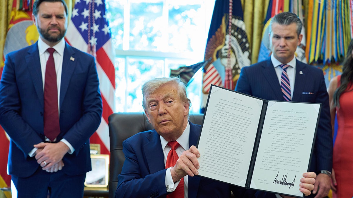 Trump holds up signed executive order at White House