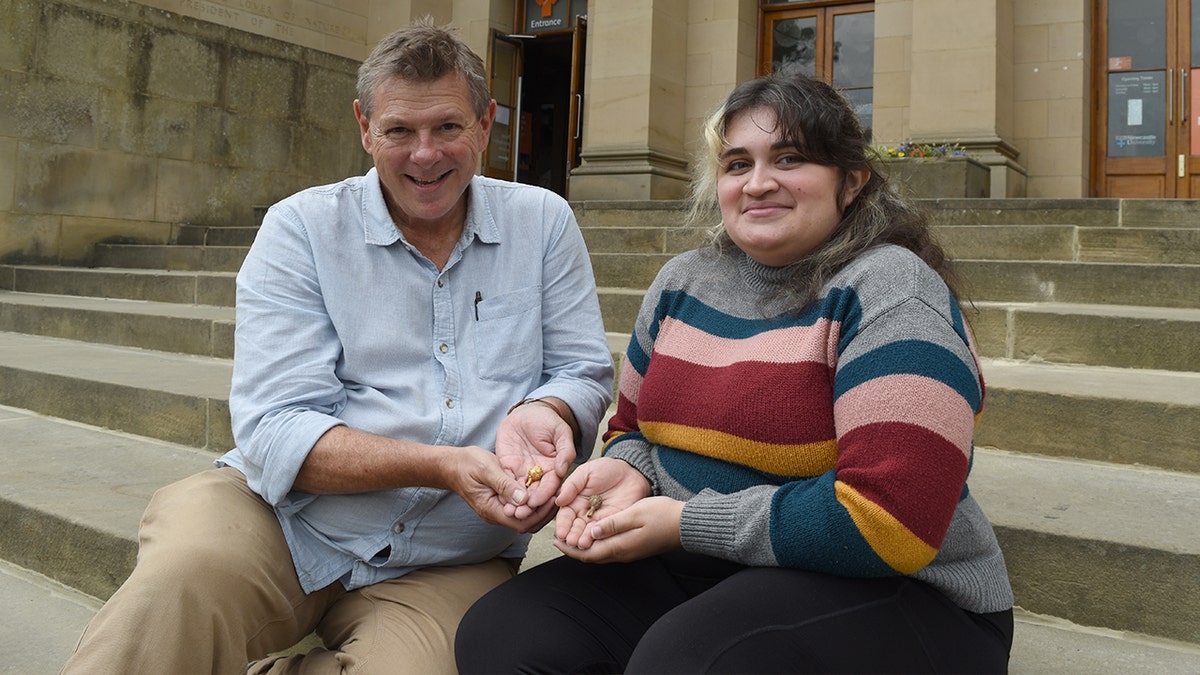 Yara holding artifact next to professor
