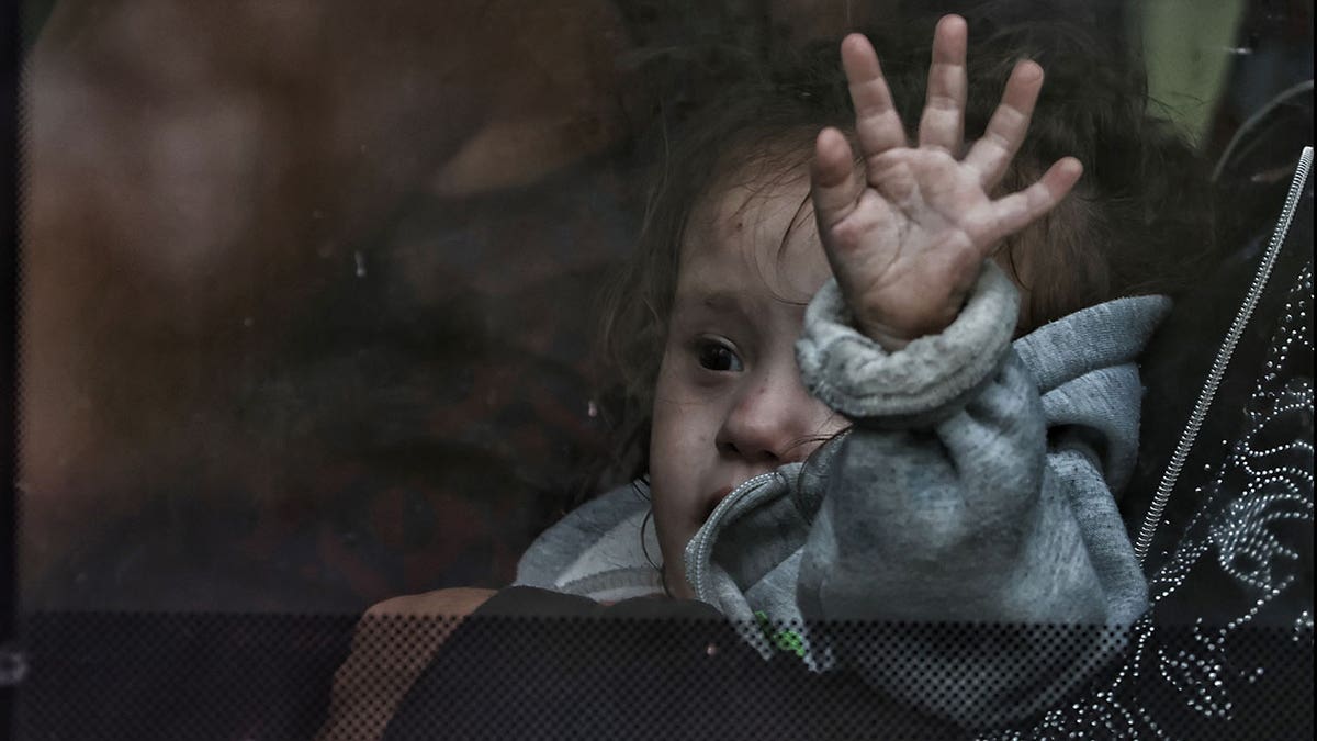 Ukrainian girl sits on evacuation bus