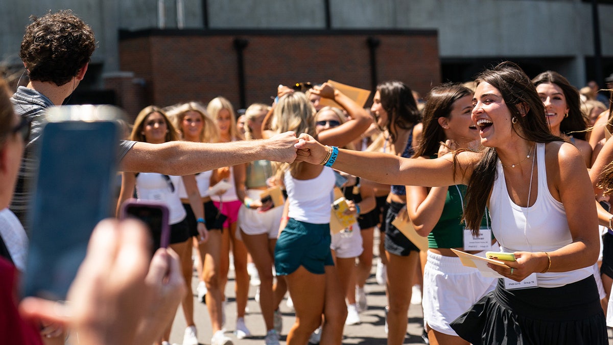New members fist bump after joining a sorority at the University of Alabama