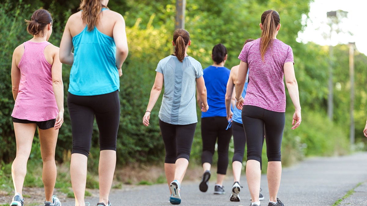 Women walking in groups with their backs facing the camera.