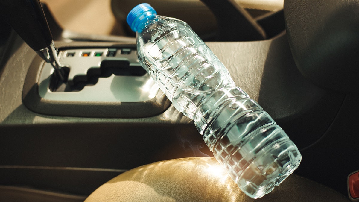 Water bottle seen sitting in a car with sun shining in on it