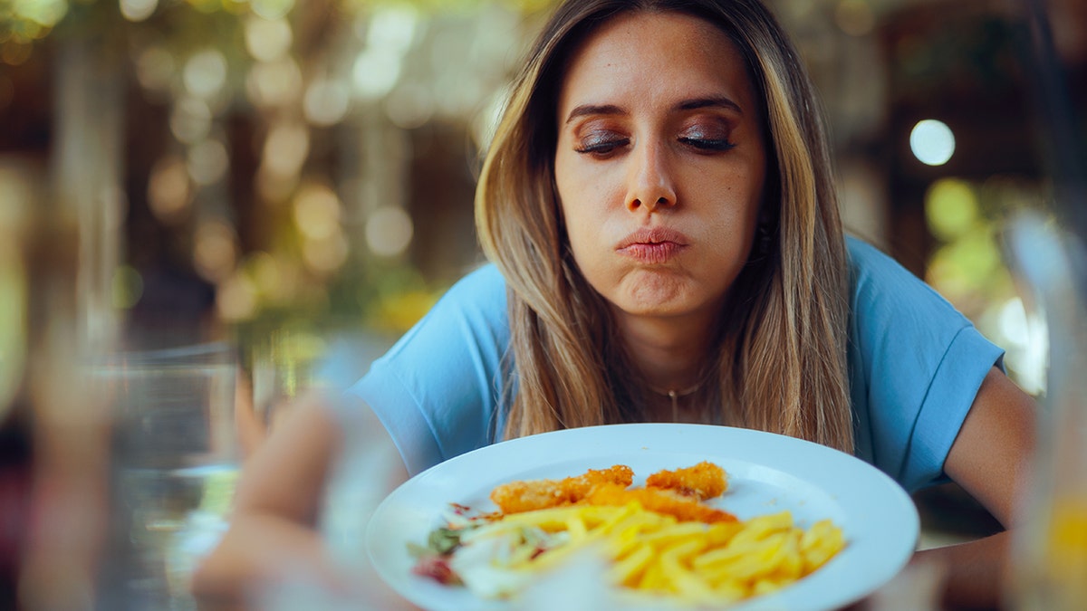 A woman who is dinner looks displeased food