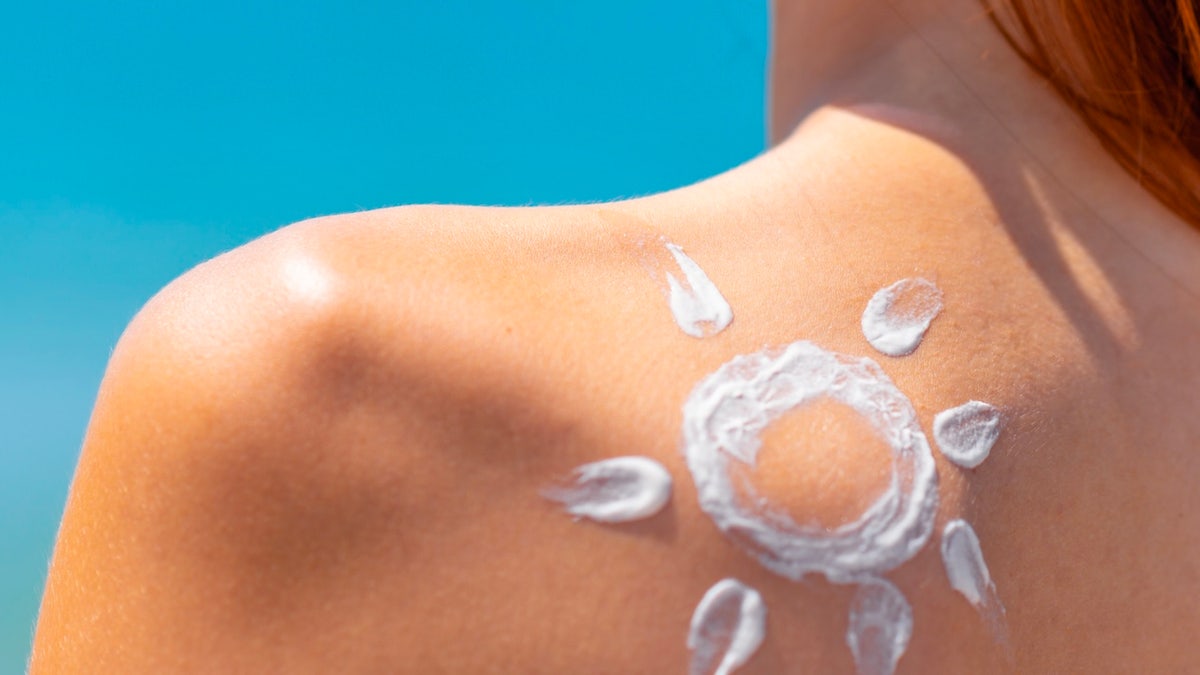 Woman wearing sunscreen on beach