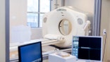 Two computer monitors are seen inside a CT scan control room