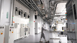 An employee walking inside of GlobalFoundries semiconductor manufacturing facility
