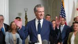 California Gov. Gavin Newsom, center, discusses the push to schedule a special election to redraw California's Congressional voting districts