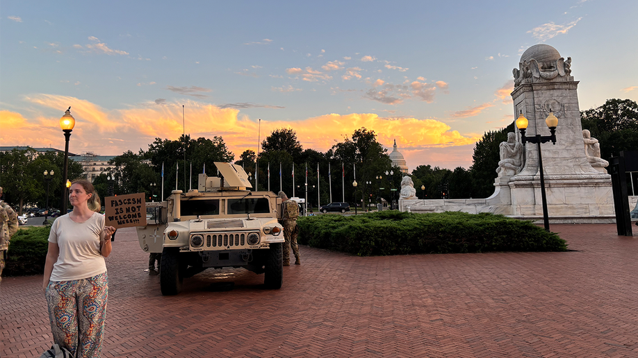 A protester stands by National Guard troops at Union Station