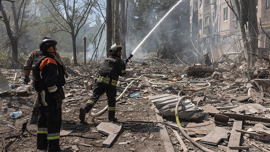 Ukrainian firefighters search for survivors after a Russian air strike on a residential building