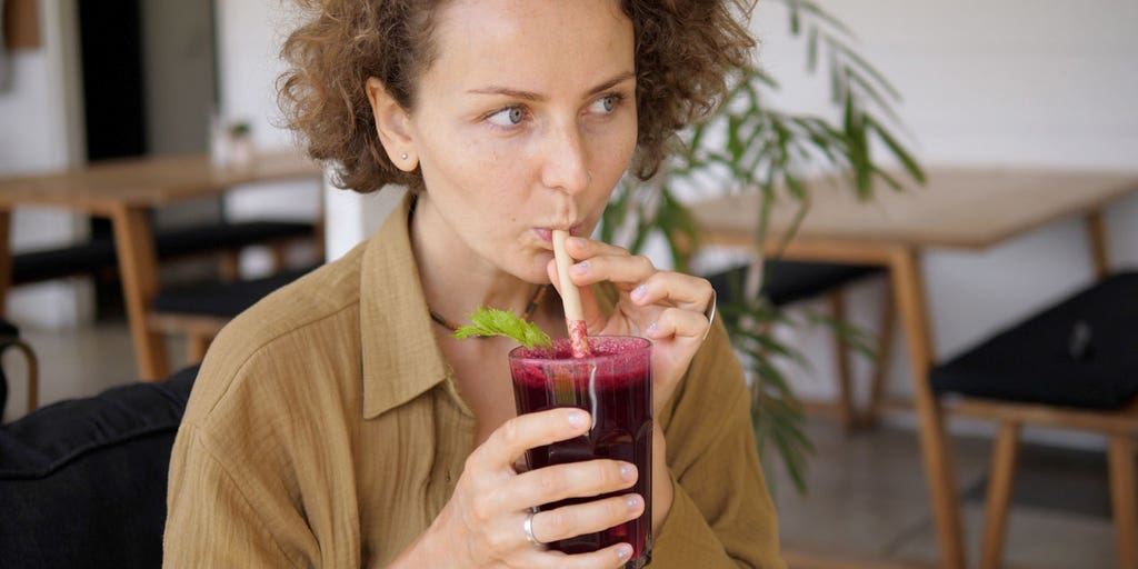 Beets and beetroot juice on a wooden surface