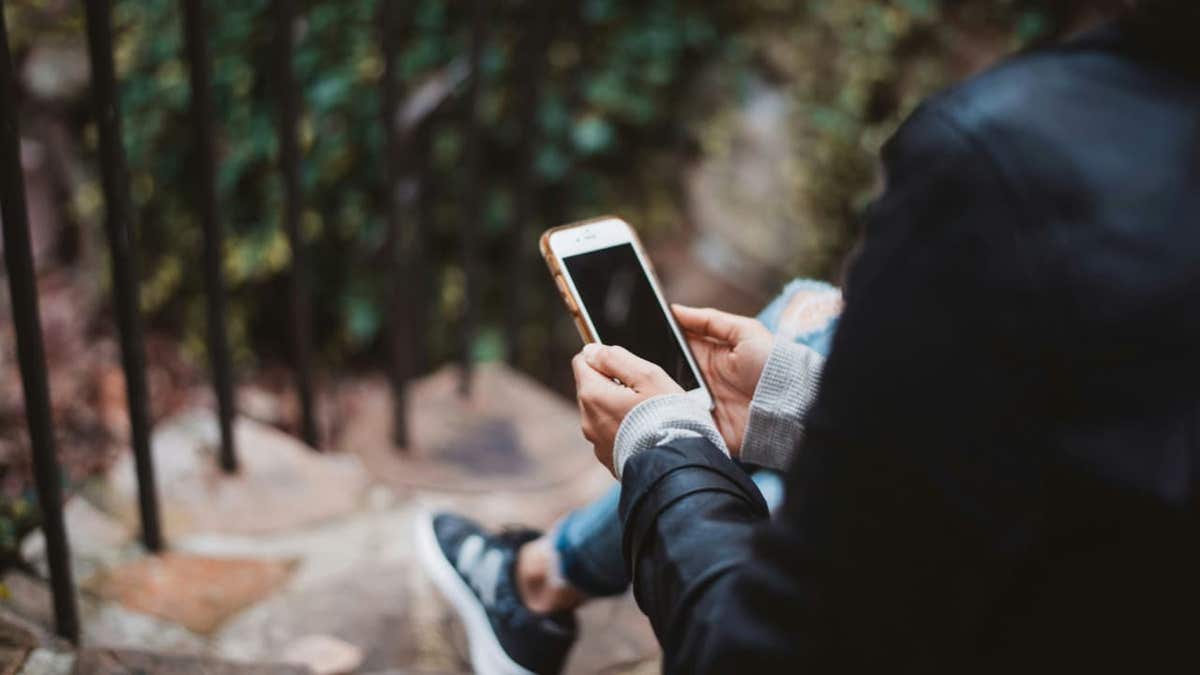 A person uses an Apple phone outside