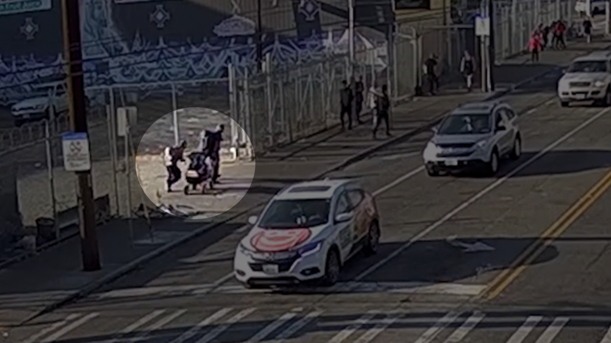 Surveillance video shows a busy intersection, with a stabbing suspect walking up behind a vicitm.