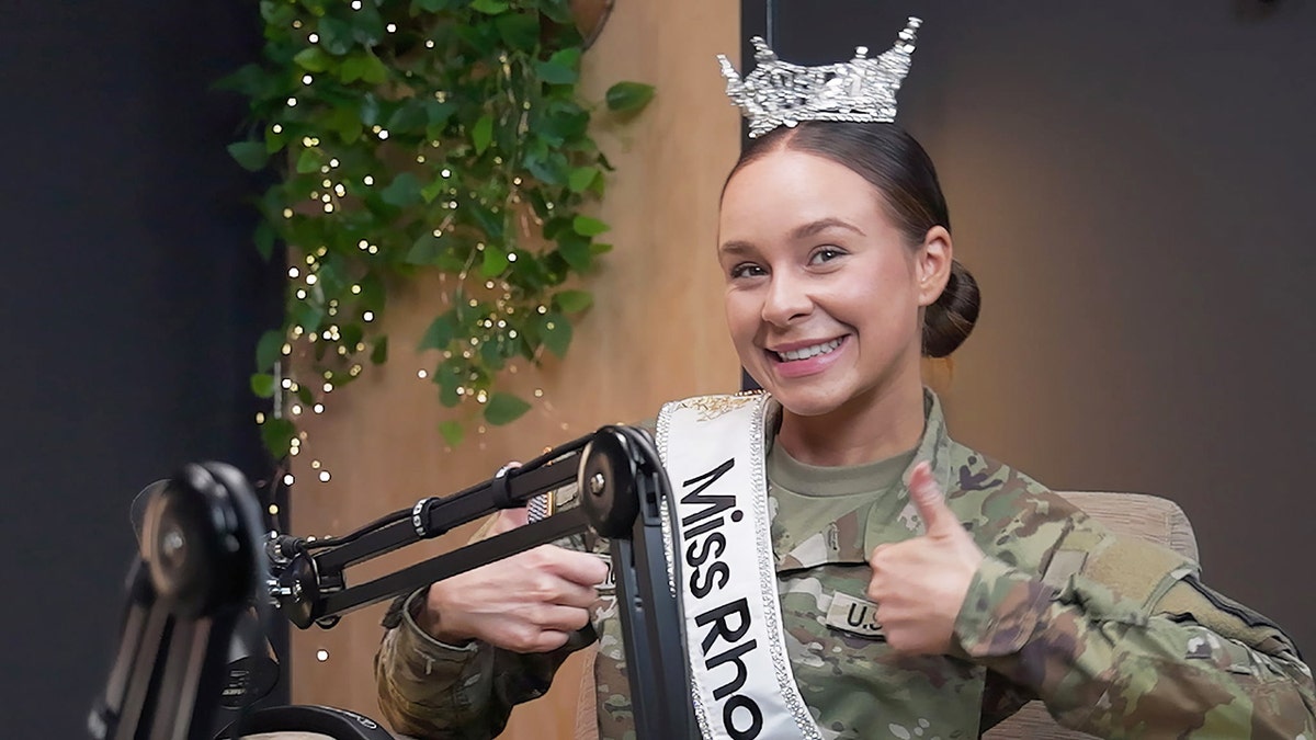 Alexia Rodrigues in Army gear wearing her crown and Miss Rhode Island sash.