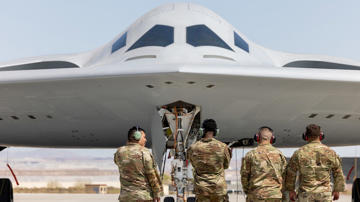 Head-on shot of B-21 with airmen facing the jet.