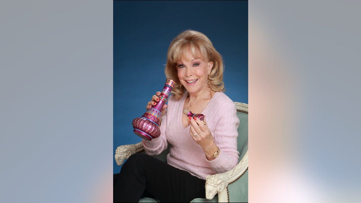 Barbara Eden holding a genie bottle.