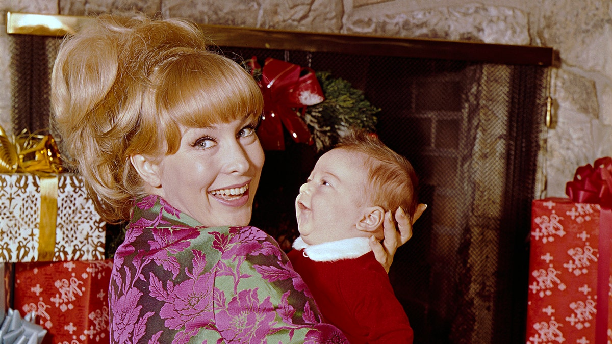 芭芭拉·伊甸園（Barbara Eden）笑著說，她的男嬰馬修·安薩拉（Matthew Ansara）微笑。