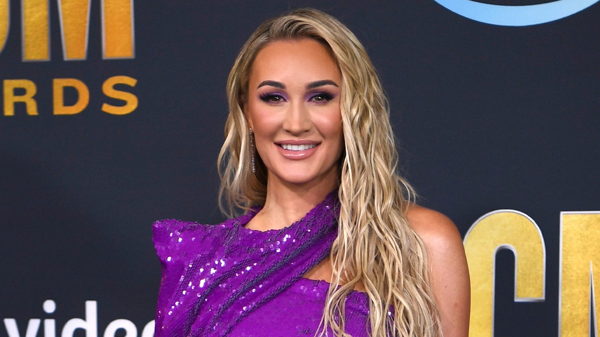 Brittany Aldean wears purple sparkling dress on red carpet