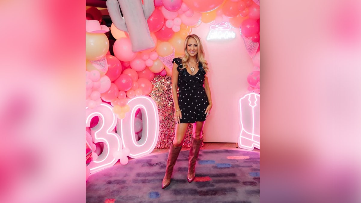 Brittany Mahomes smiles wearing cowboy boots and polka dot dress