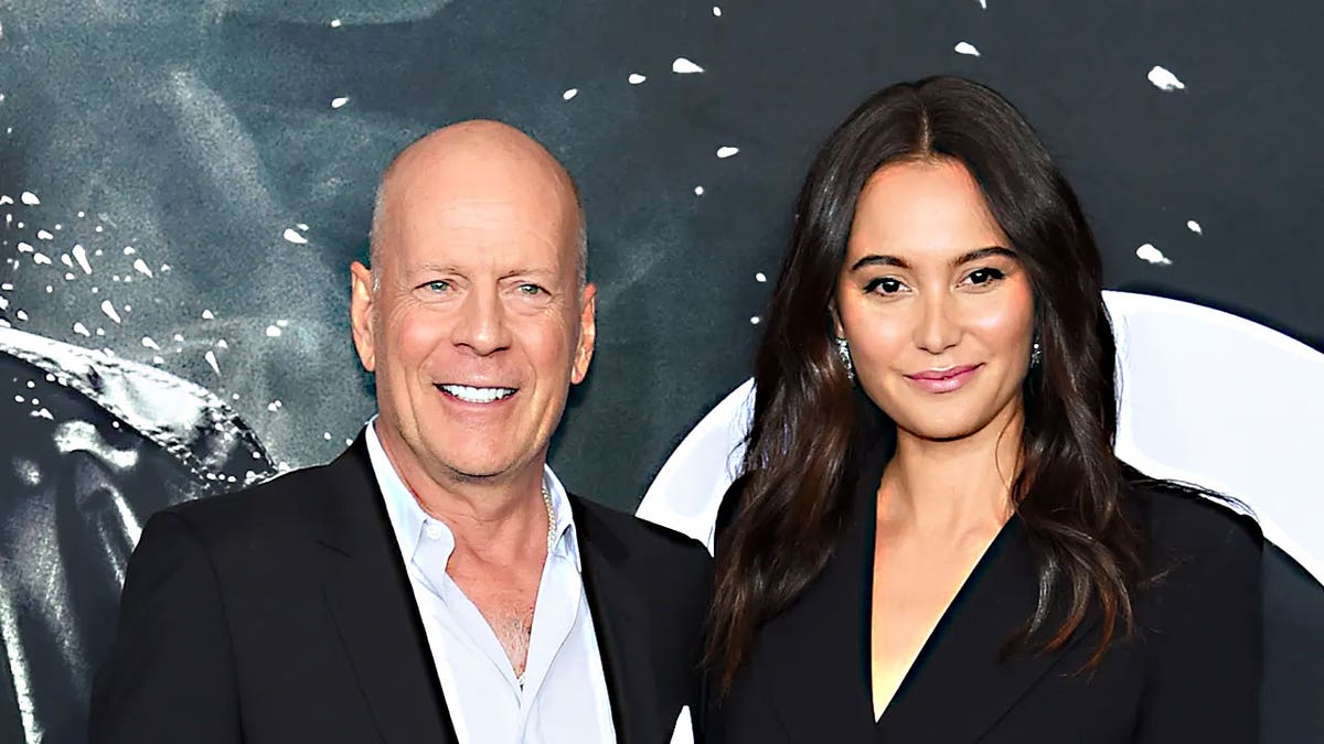 Bruce Willis smiling next to his wife, Emma Heming Willis, on the red carpet before his FTD diagnosis.