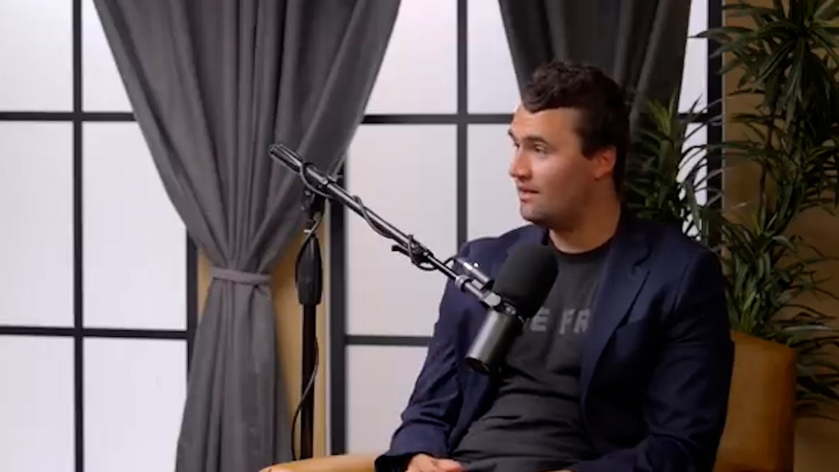 Charlie Kirk sits in front of the microphone during interview
