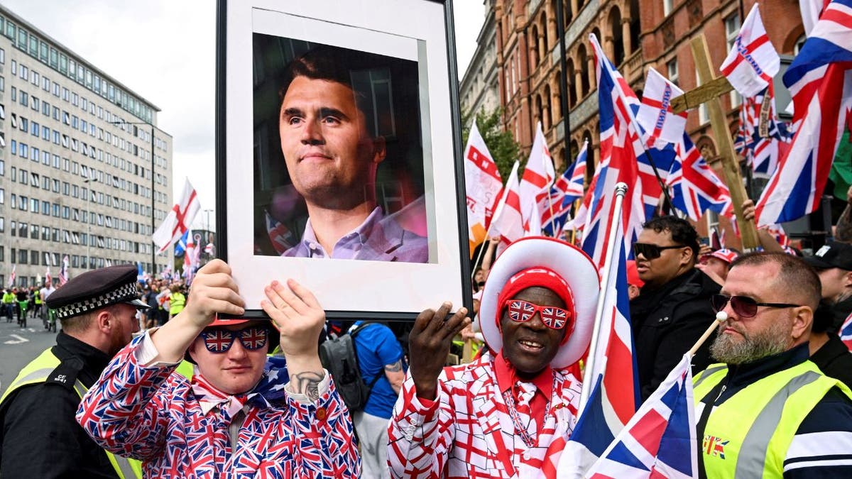 Man holds framed photo of Charlie Kirk at London rally