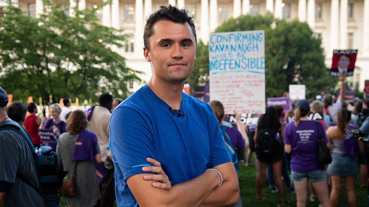 Charlie Kirk in T-shirt with folded hands