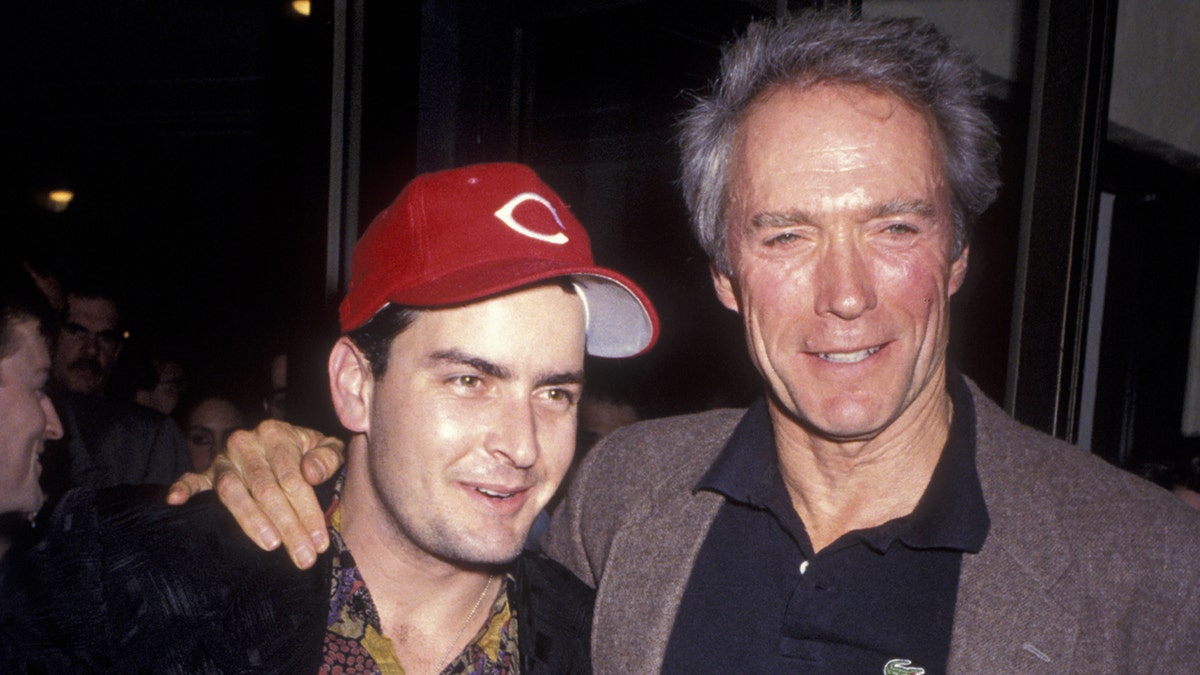 Charlie Sheen wears red Cincinnati hat with Clint Eastwood