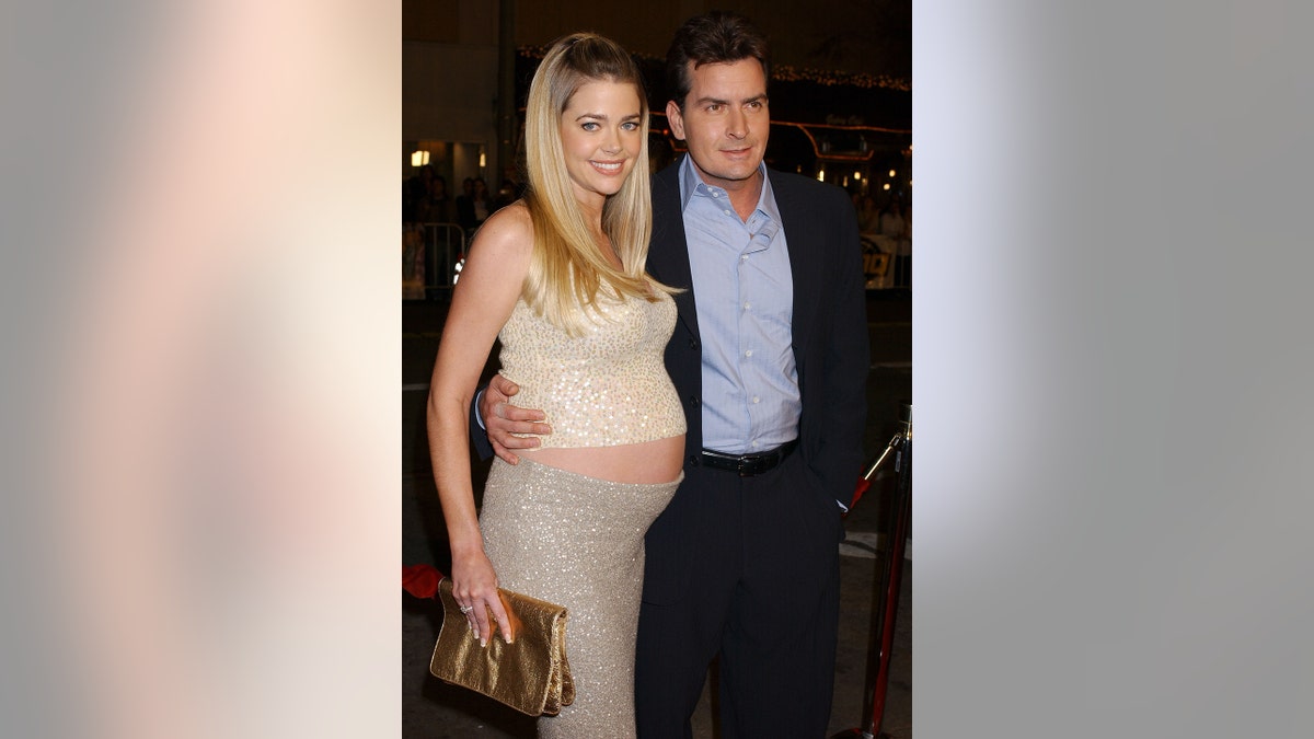 Charlie Sheen with his arms around a pregnant Denise Richards.