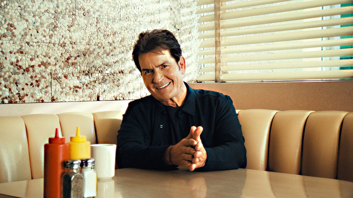 Charlie Sheen smiling at a diner.