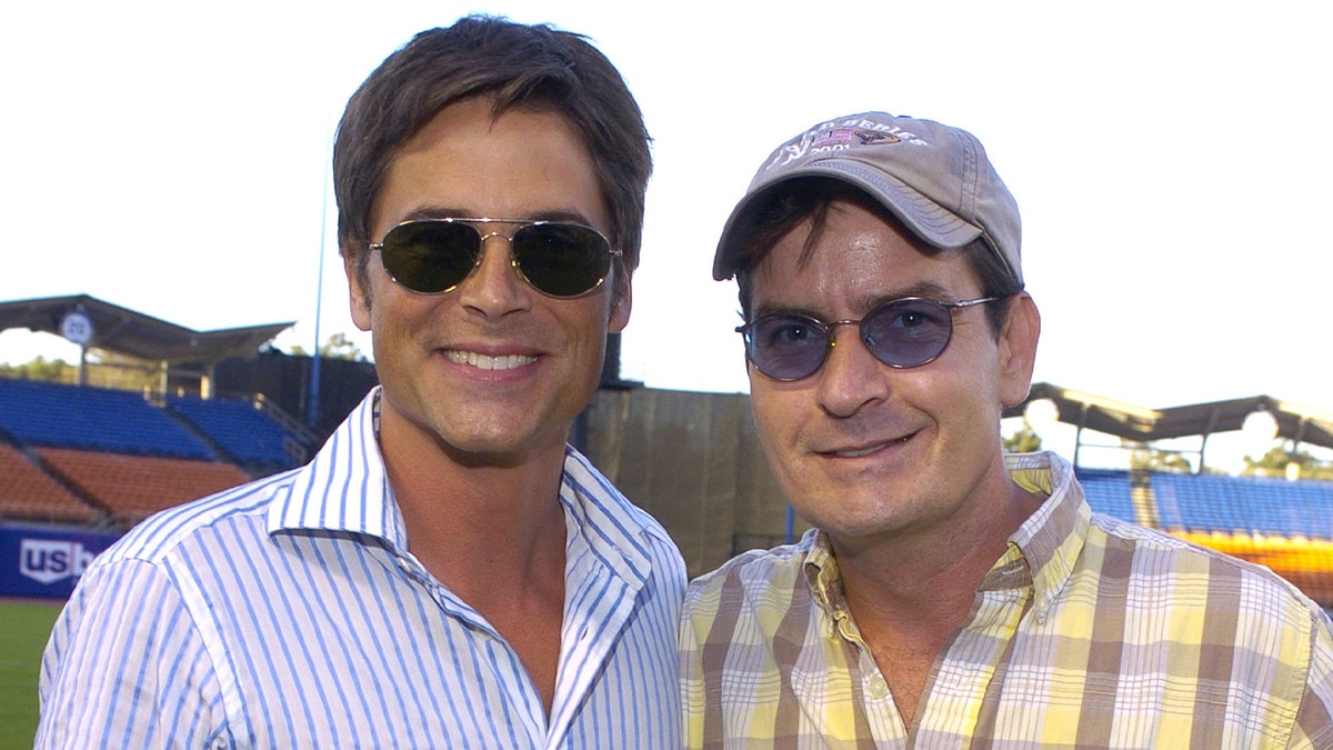 Charlie Sheen wears a hat with Rob Lowe in striped shirt.