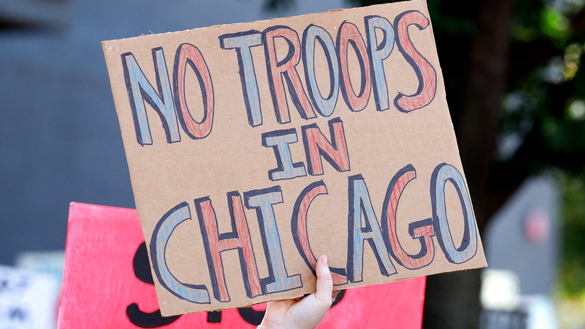 The protester holds a mark during a demonstration in Chicago, where President Donald Trump looks at the spread of the National Guard of the city to help curb the violent crime.