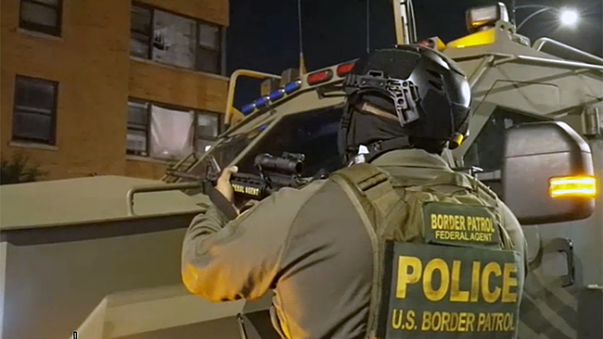U.S. Border Patrol agent points weapon during immigration operation in Chicago