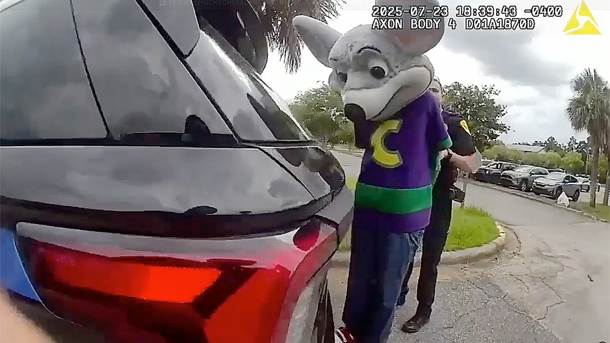 Chuck E. Cheese next to police patrol car