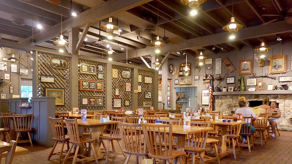Three customers sit inside a mostly empty Cracker Barrel Old Country Store restaurant.