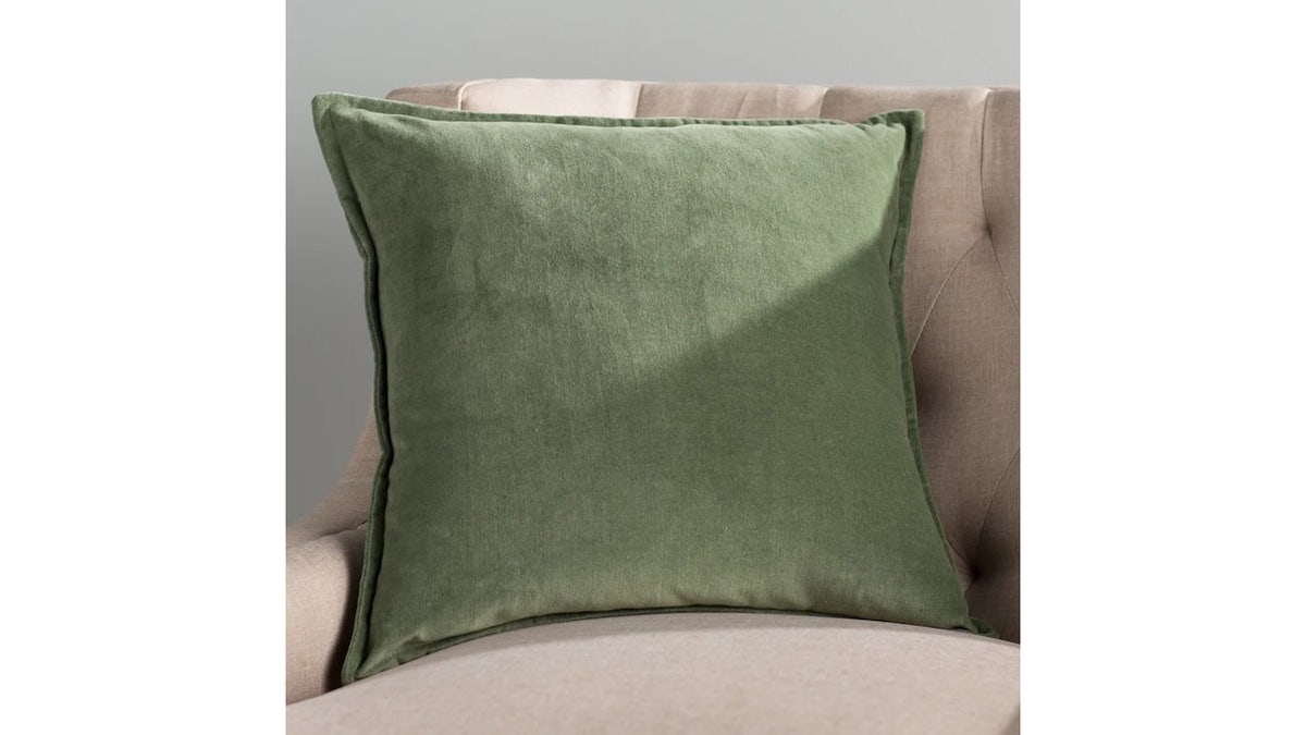 Shape a cozy sitting area with this velvet-like throw pillow.
