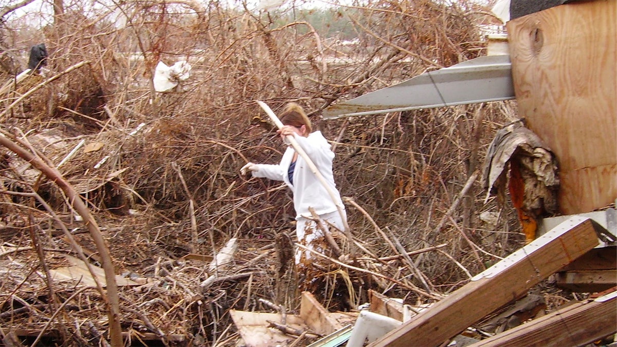 Woman walks through storm debris after Hurricane Katrina in Buras, LA.