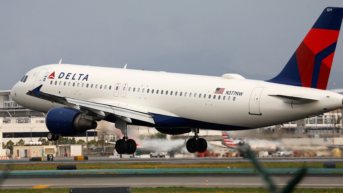 A Delta Airlines Airbus A320 arrives at Los Angeles International Airport from Dallas on March 28, 2025 in Los Angeles, California, seen landing on tarmac with airport in background.