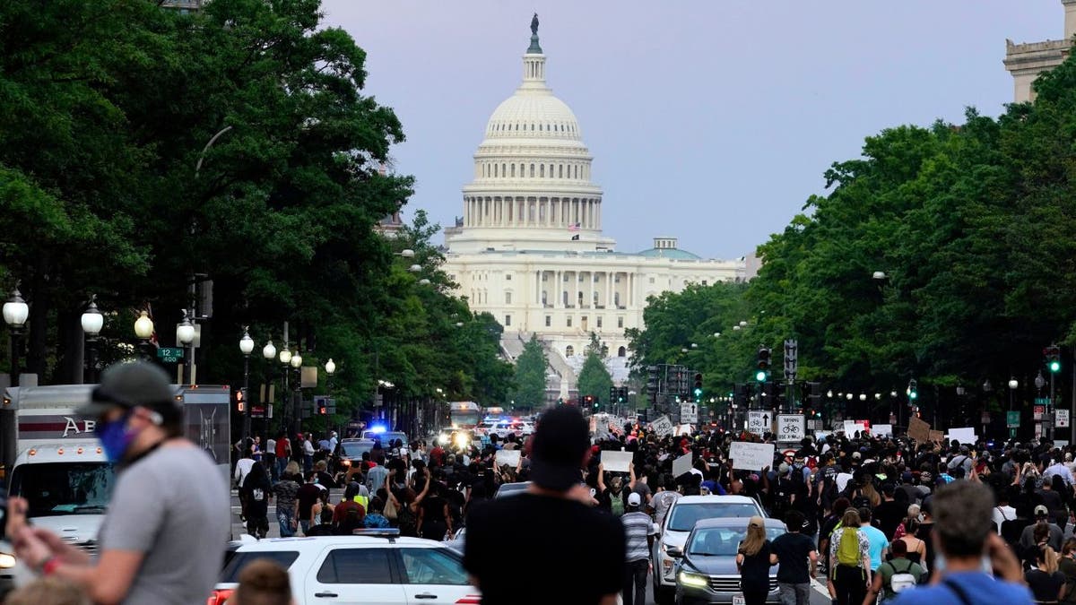 Crowd of demonstrators marching toward the U.S. Capitol during George Floyd protest.
