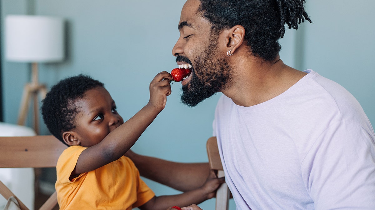The son eats strawberry