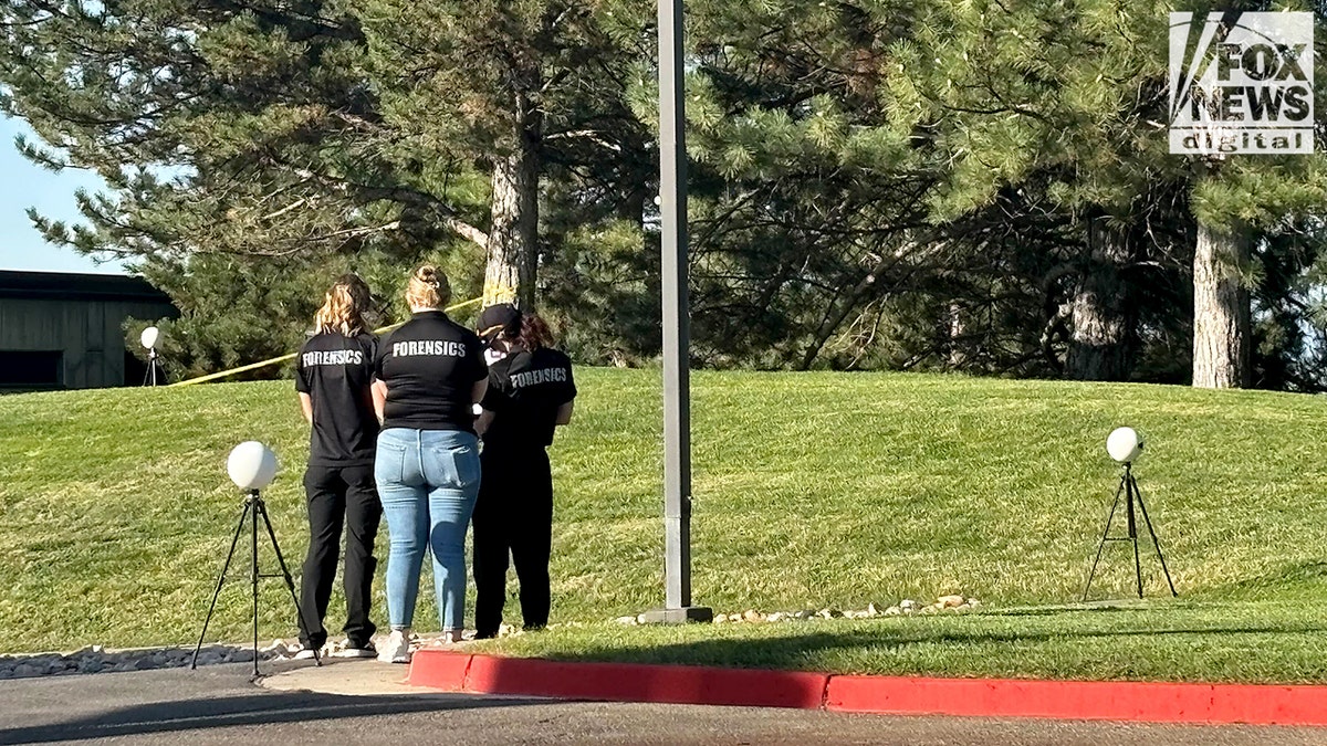 Forensics team scanning for evidence in a field