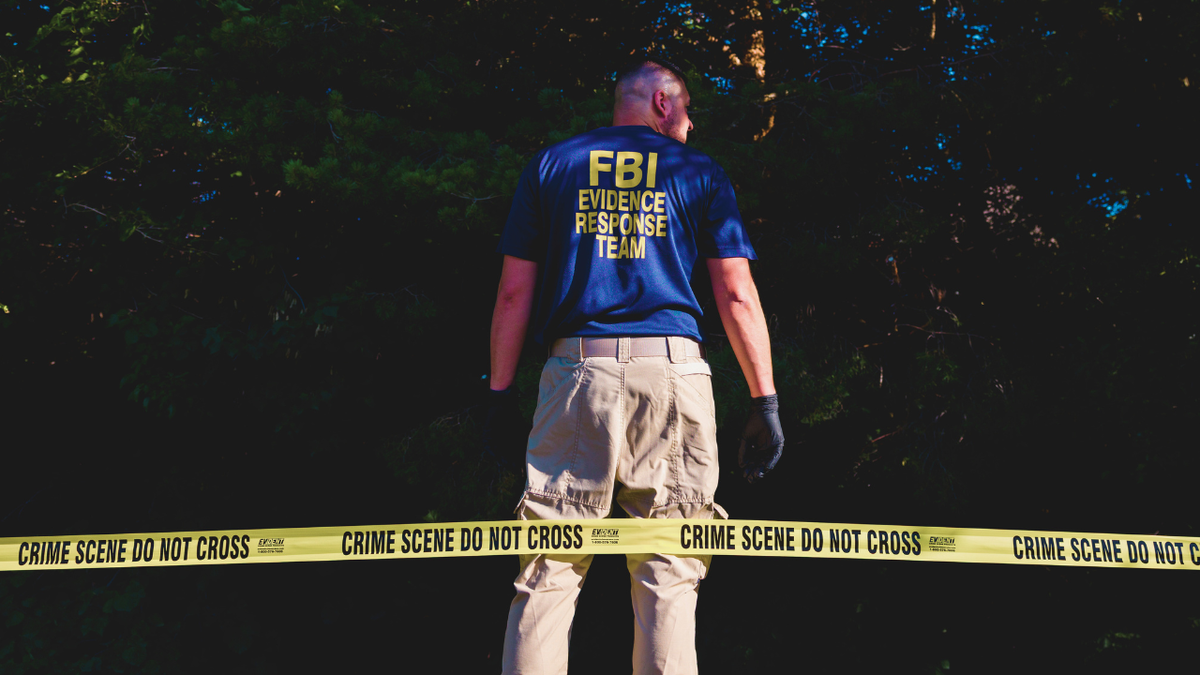 An FBI agent looks for evidence near Utah Valley University where Charlie Kirk was assassasinated