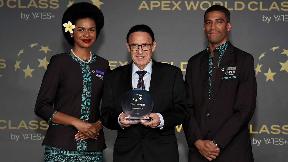 Andre Viljoen, center, and Fiji Airways crew members attending Fiji Airways x APEX/IFSA Global EXPO 2025 at Long Beach Convention & Entertainment Center on September 11, 2025 in Long Beach, California. Vilijoen seen holding top 10 Worlds Best award