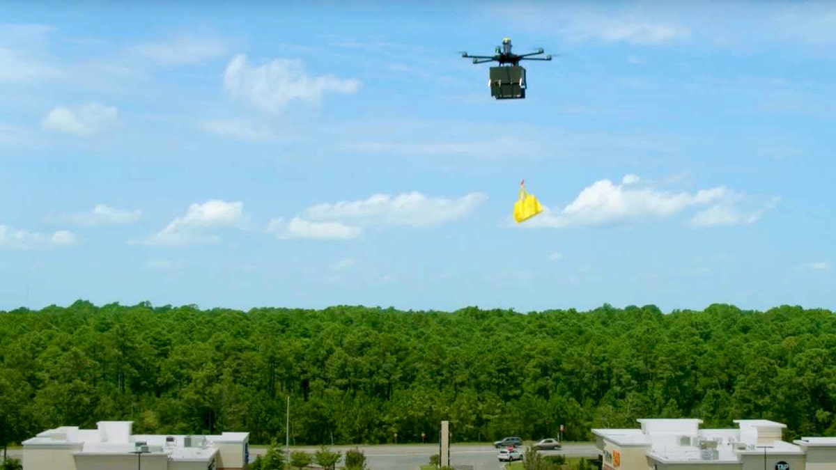 A Flytrex drone with a grocery bag over a parking lot